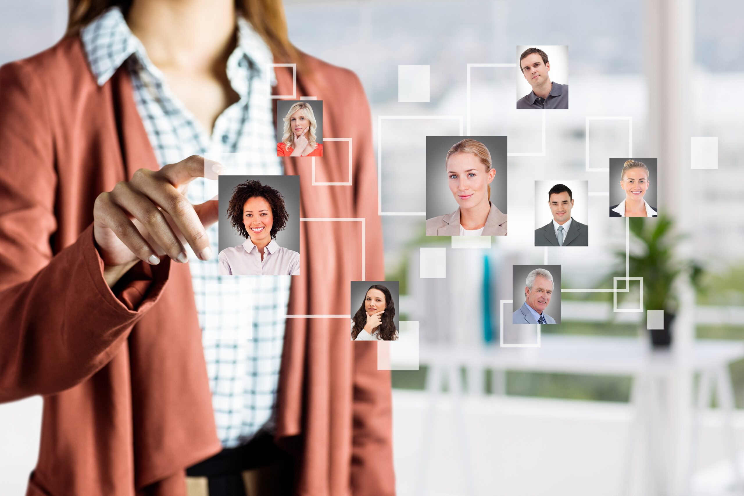 Businesswoman interacting with a digital interface displaying various headshots of people, representing customer segmentation models for targeted marketing and personalized communication.